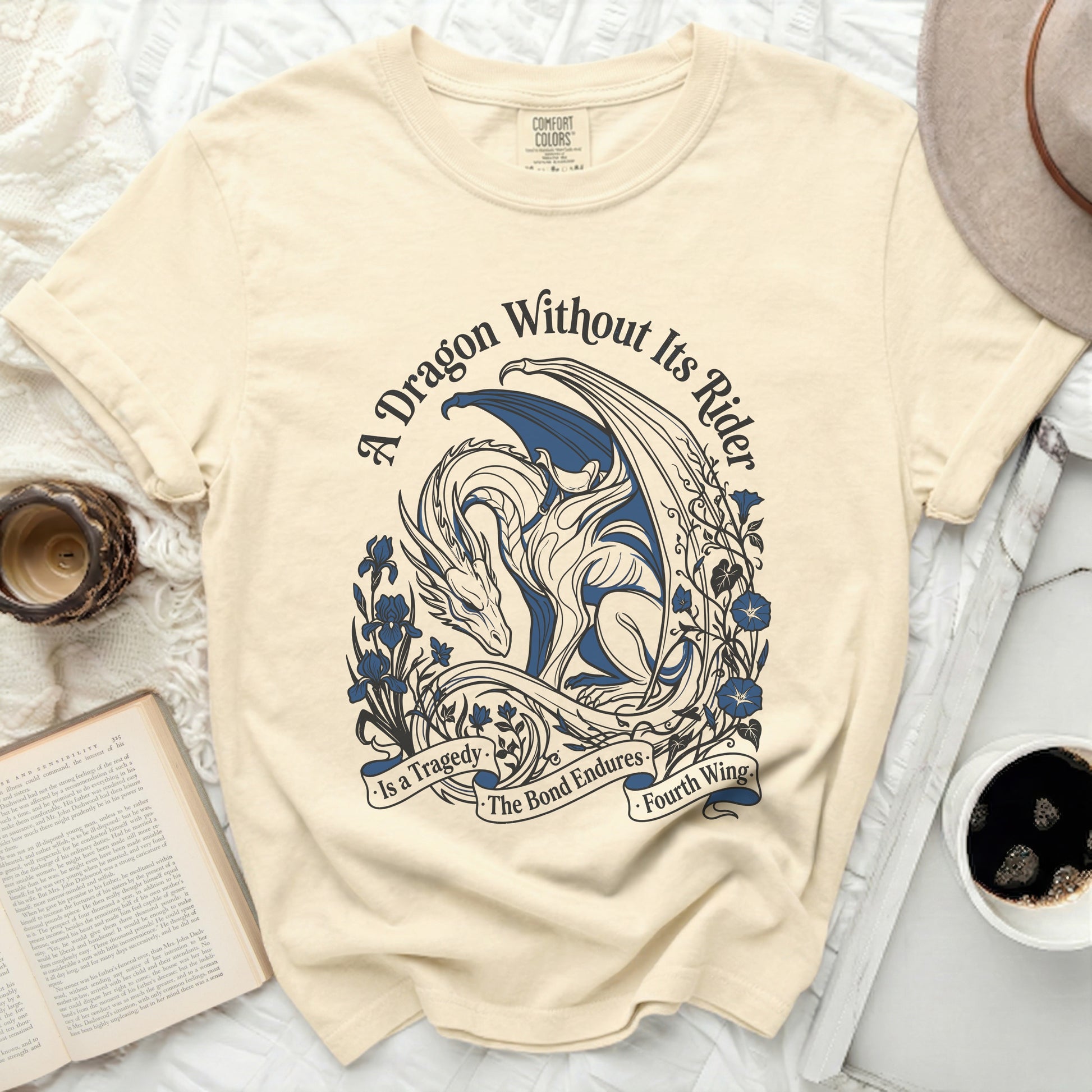Cream t-shirt with blue dragon design and text "A Dragon Without Its Rider is a Tragedy. The Bond Endures. Fourth Wing."