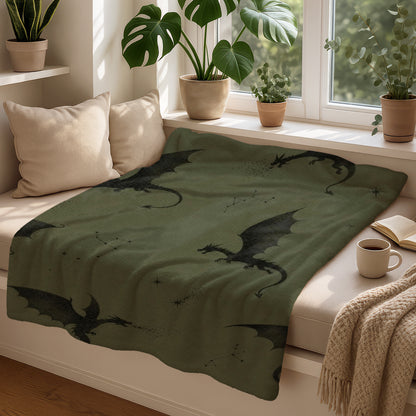 Green blanket with black dragon print and constellations on a window seat