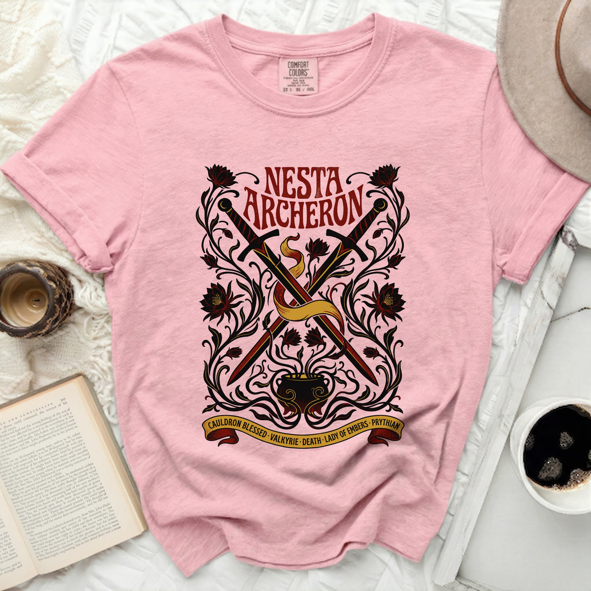 Pink t-shirt with "Nesta Archerton" and swords graphic.