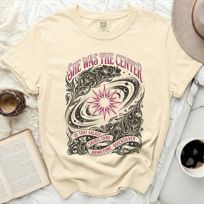 Cream t-shirt with "She was the center of that galaxy" starry design.