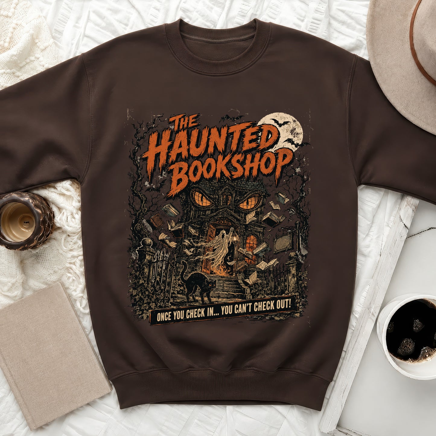 Brown sweatshirt with "The Haunted Bookshop" graphic and spooky theme.