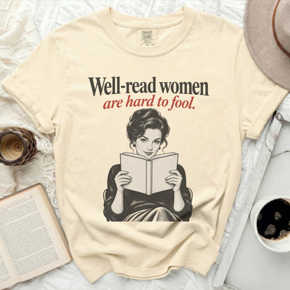 Cream t-shirt with "Well-read women are hard to fool" text and a vintage illustration of a woman reading.