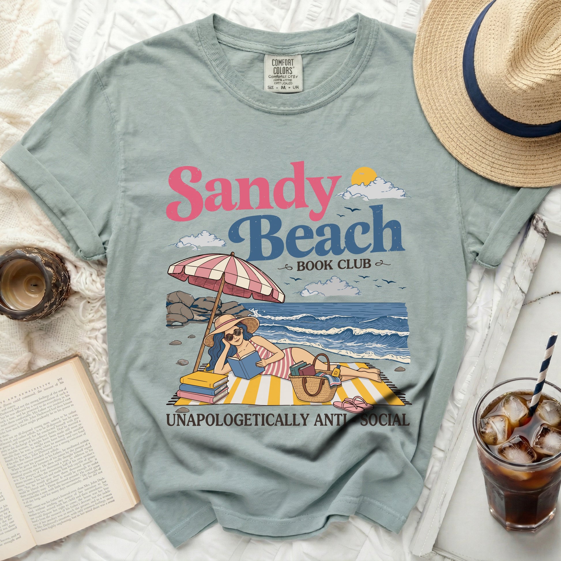 Green Comfort Colors t-shirt with "Sandy Beach Book Club" and "Unapologetically Anti Social" graphic.