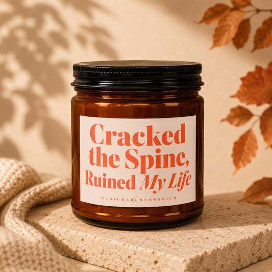 Amber candle with "Cracked the Spine, Ruined My Life" text on label.