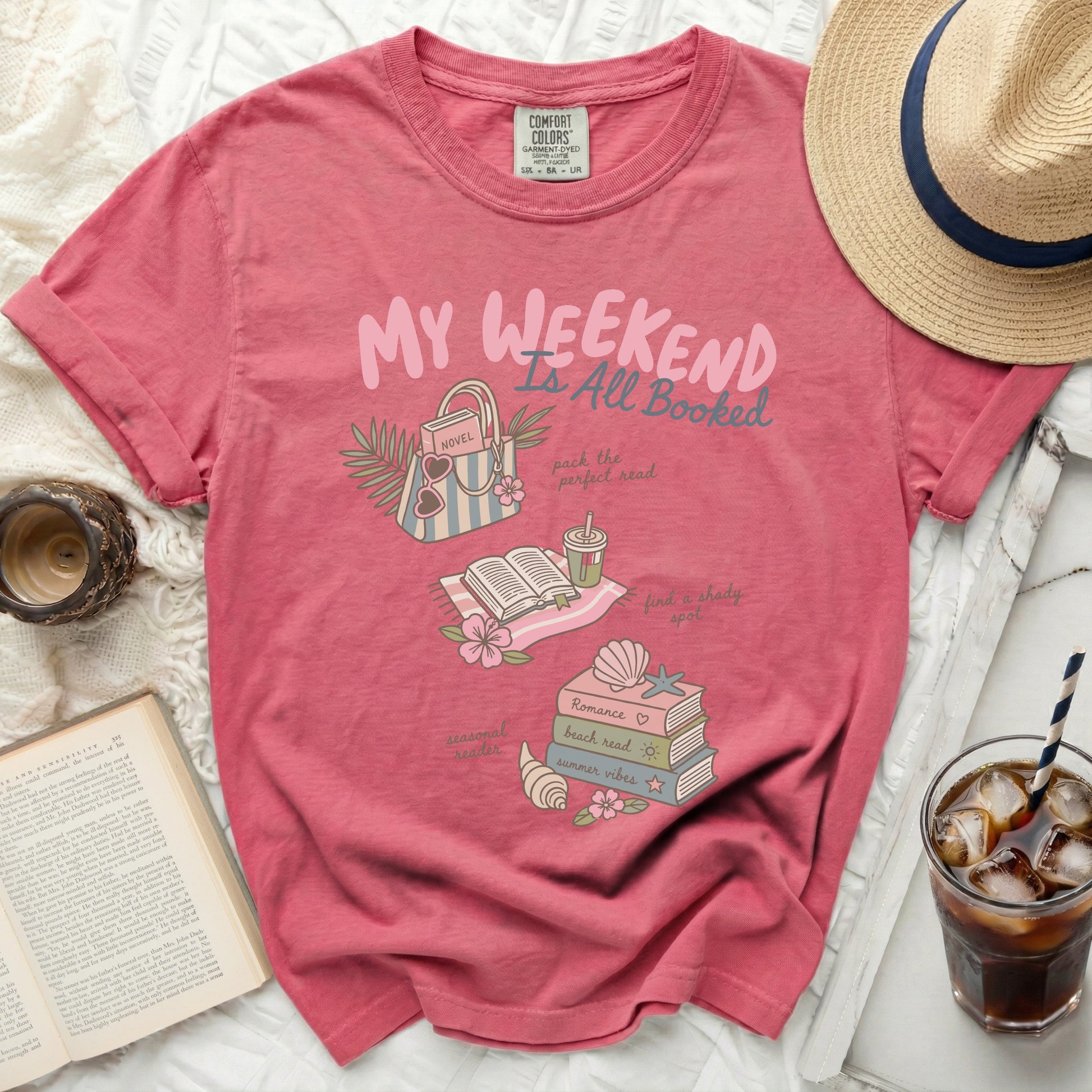Pink t-shirt with "My Weekend Is All Booked" graphic and book-related illustrations.