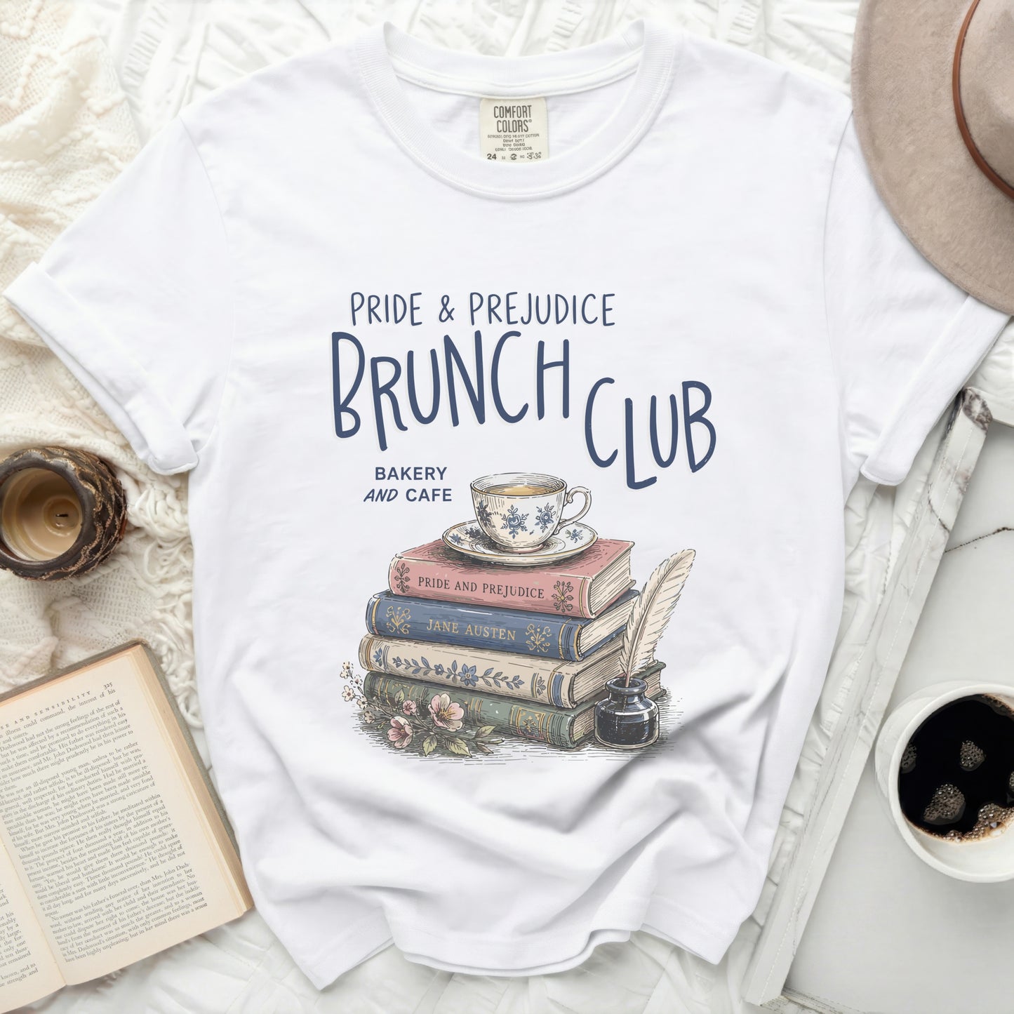 White t-shirt with "Pride & Prejudice Brunch Club" graphic and stack of books.