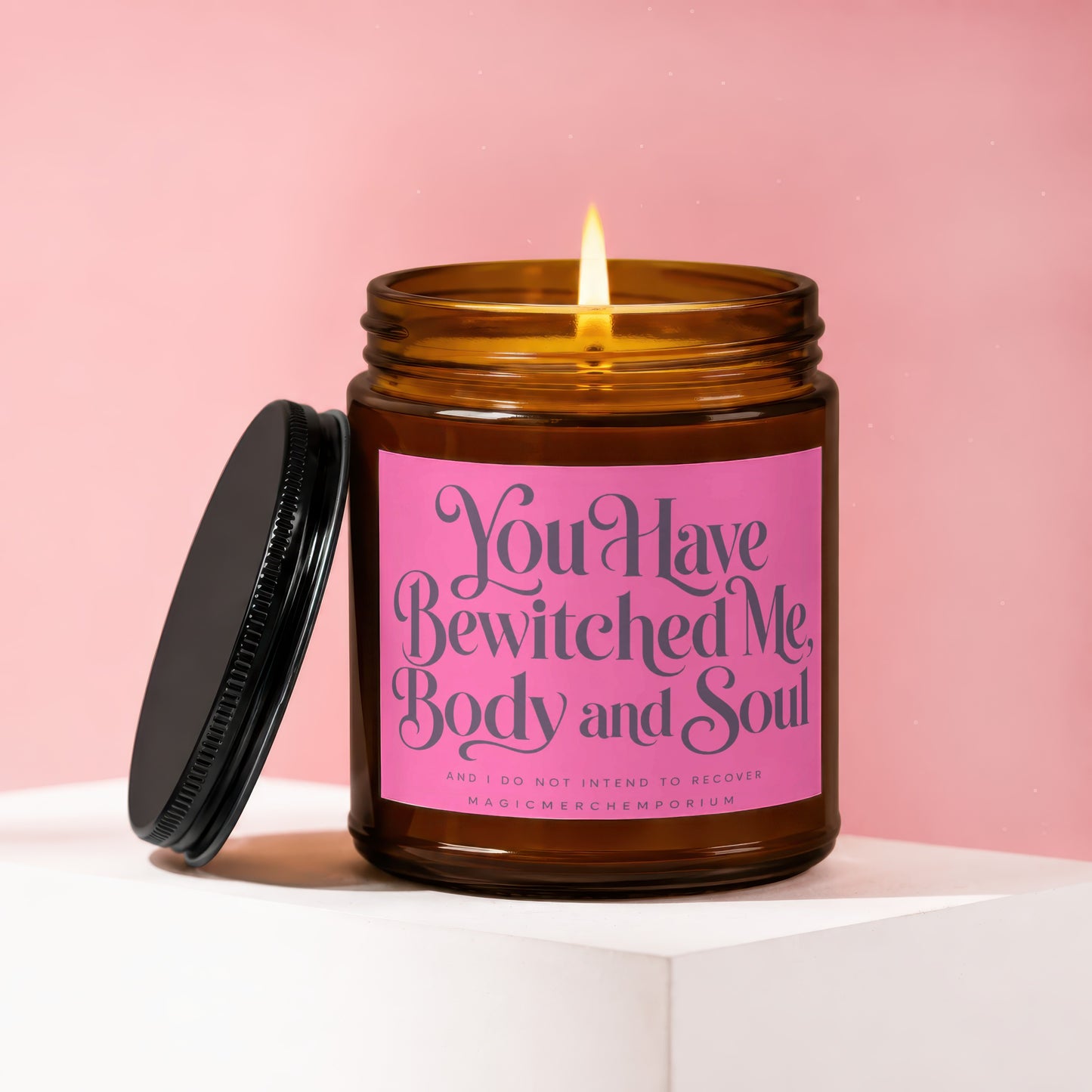 Amber jar candle with pink label reading "You Have Bewitched Me, Body and Soul."