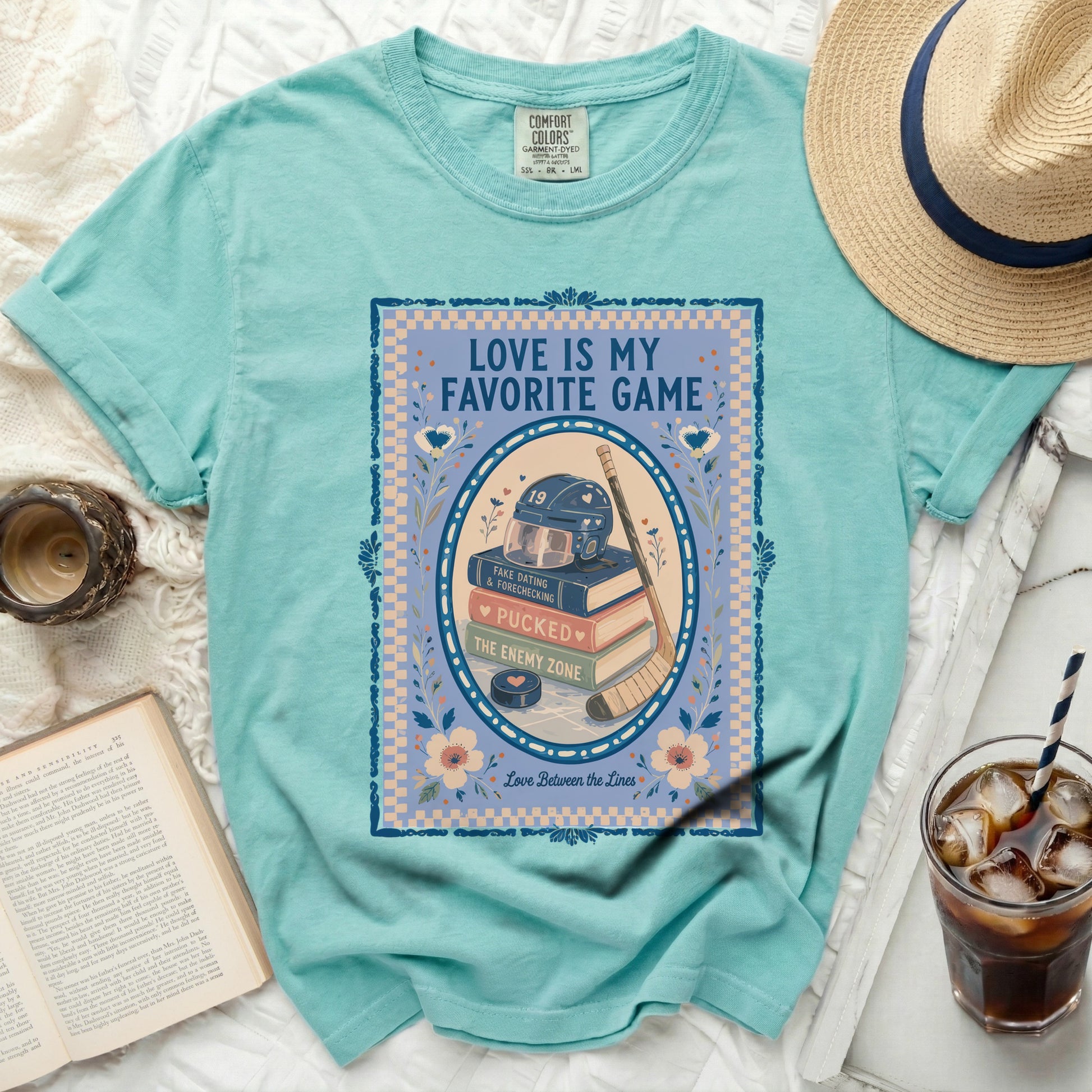 Teal t-shirt with "Love is My Favorite Game" text and hockey imagery.