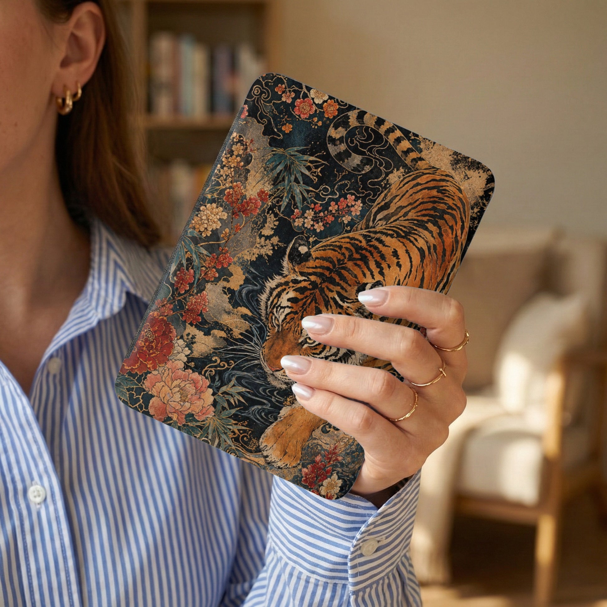 Woman holds a case with a tiger and floral design.