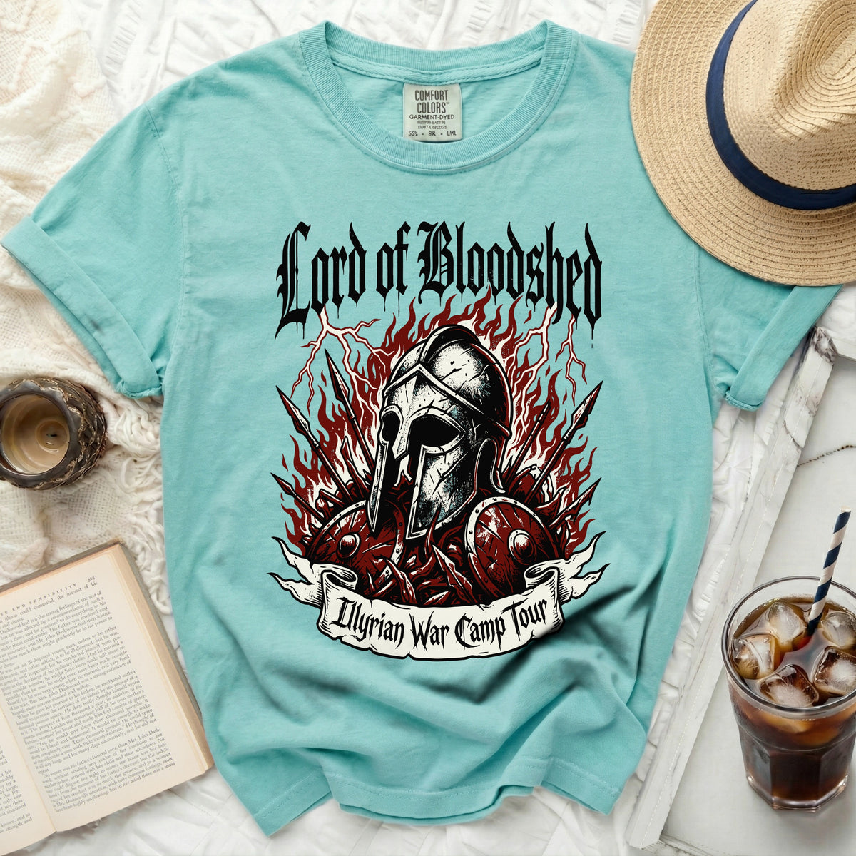 Turquoise t-shirt with "Lord of Bloodshed Illyrian War Camp Tour" graphic.