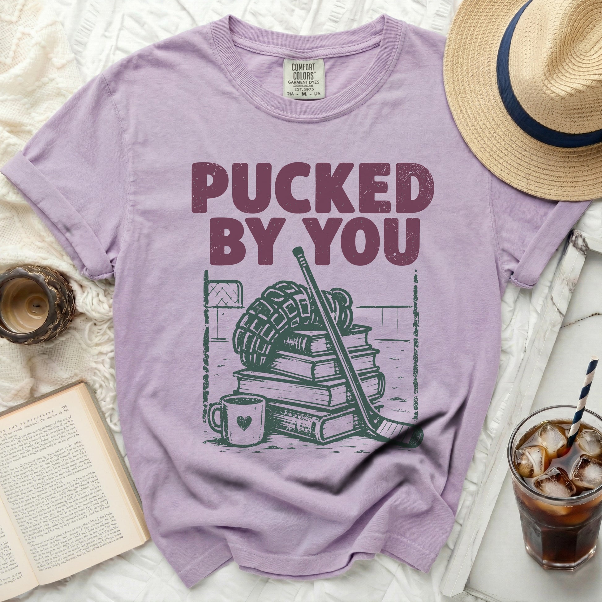 Purple t-shirt with "Pucked By You" text and hockey gear graphic.