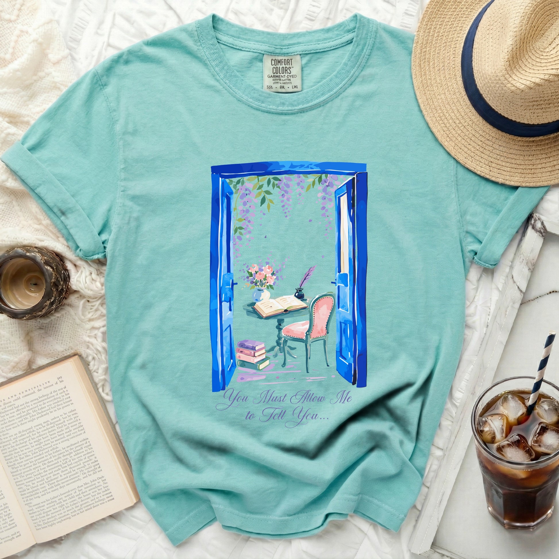 Teal t-shirt with watercolor art of open blue doors, a desk setup, and "You Must Allow Me to Tell You..." text.