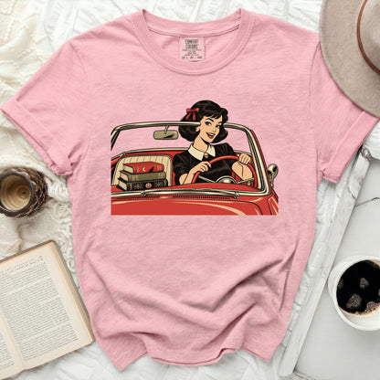 Pink Comfort Colors t-shirt with graphic of woman driving a red convertible with books.