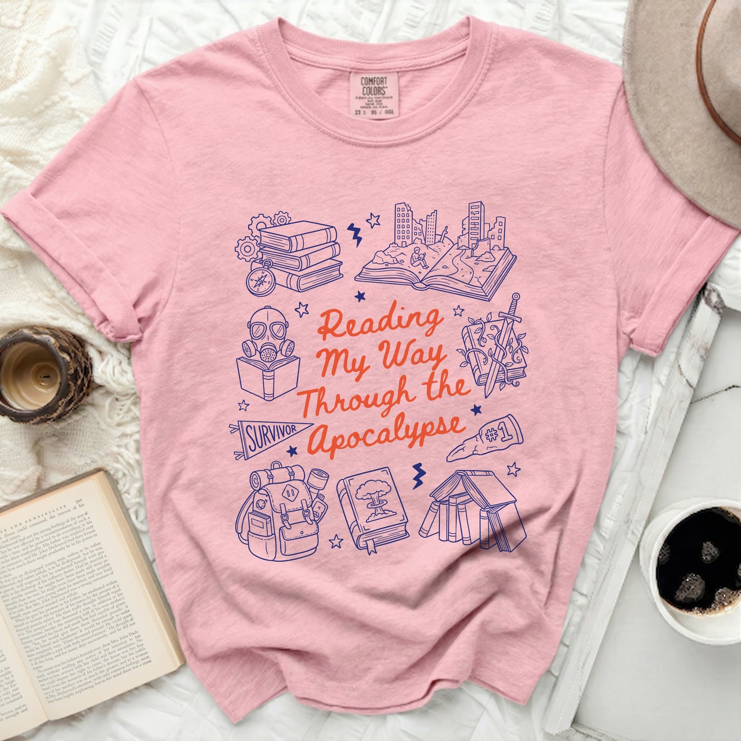 Pink t-shirt with "Reading My Way Through the Apocalypse" and survival-themed graphics.