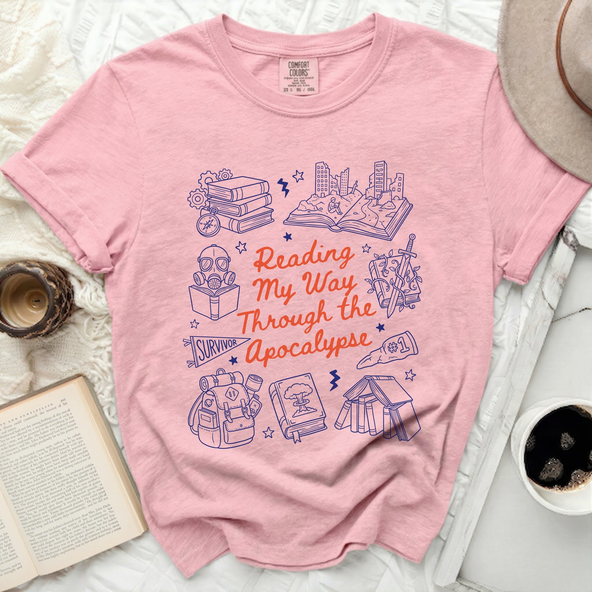 Pink t-shirt with "Reading My Way Through the Apocalypse" and survival-themed graphics.