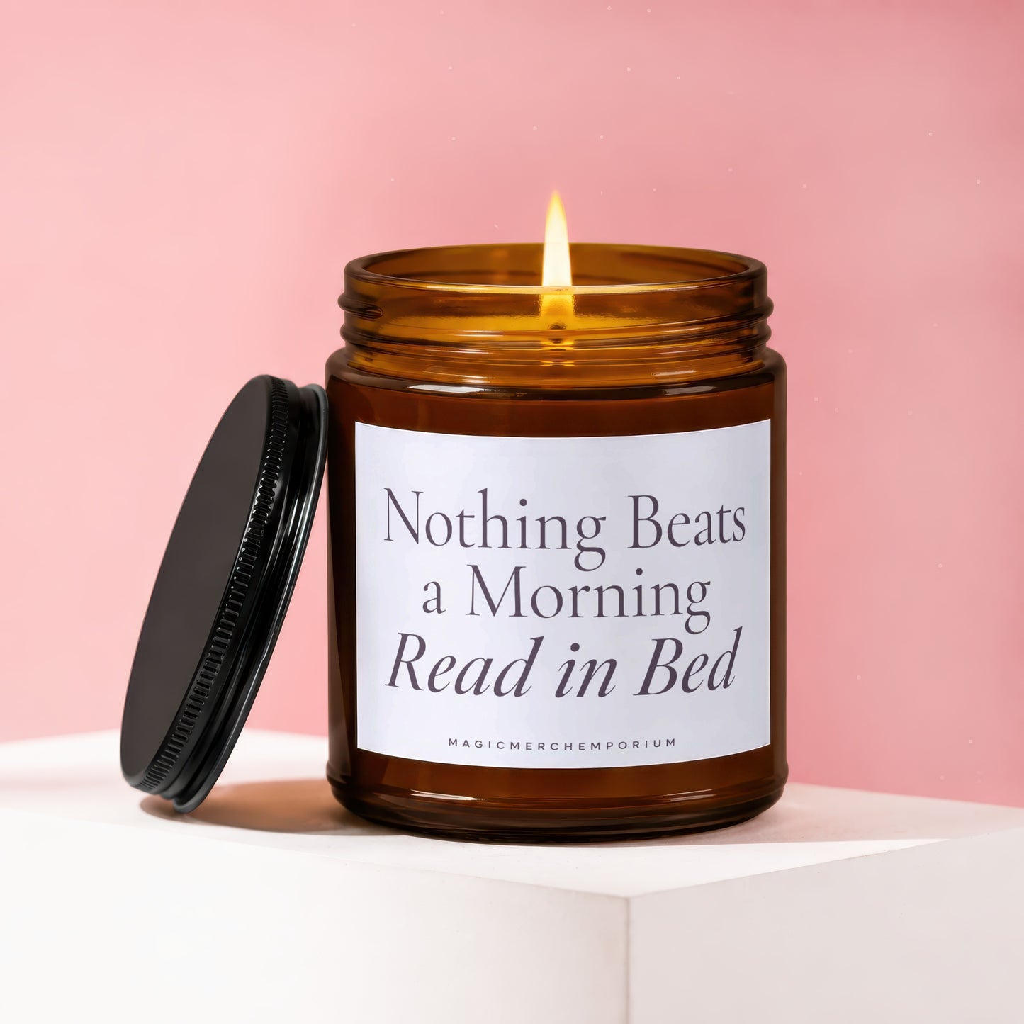 Amber candle with lit wick and text "Nothing Beats a Morning Read in Bed".