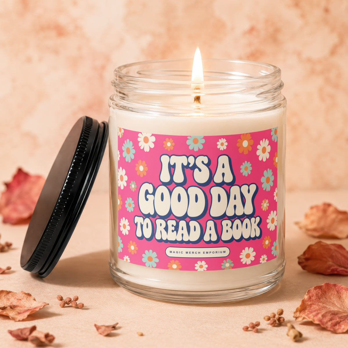 Candle with lit wick and "It's a Good Day to Read a Book" text on a pink floral label.