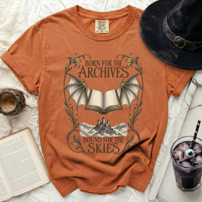 Orange t-shirt with "Born for the Archives, Bound for the Skies" text and winged book graphic.