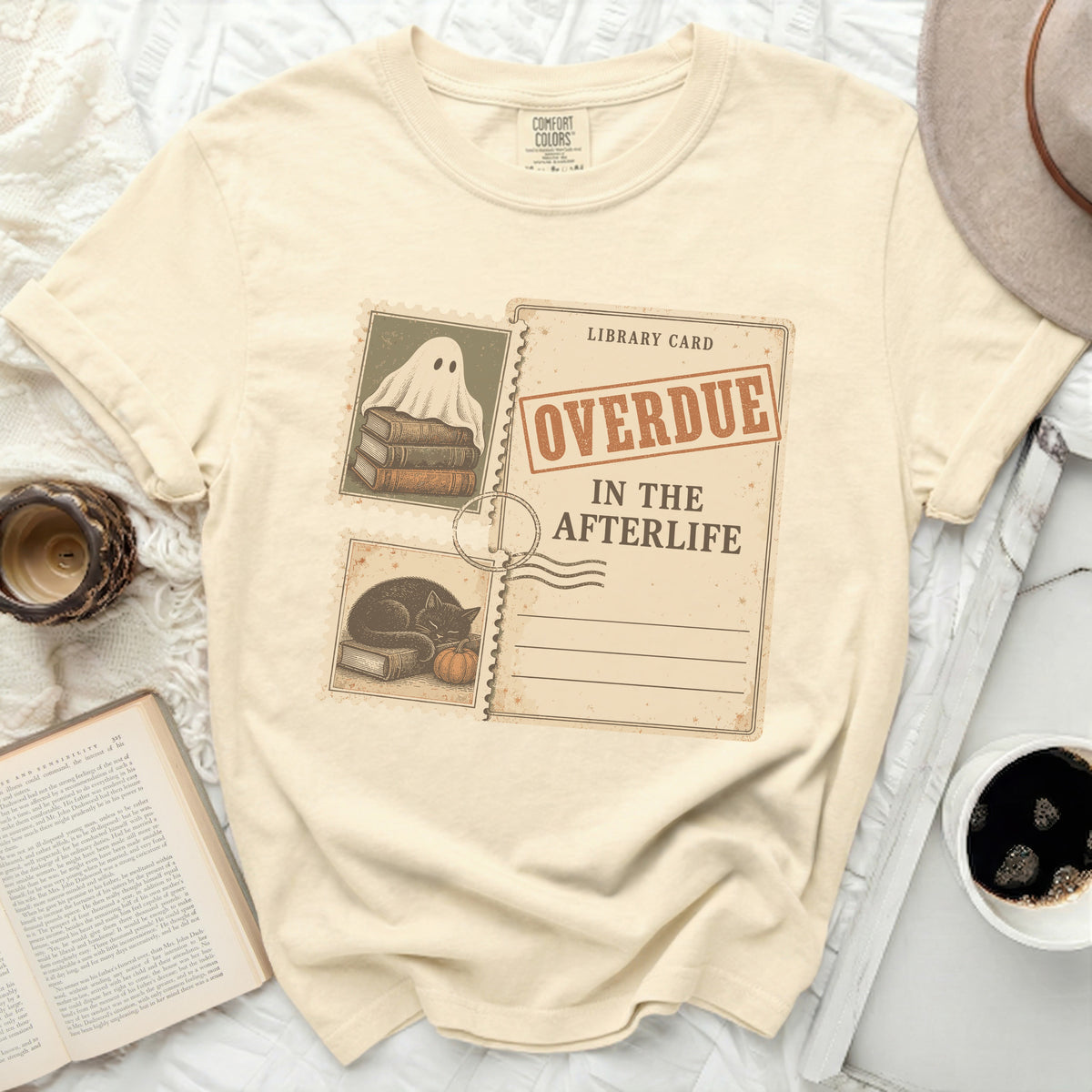 Cream t-shirt with "Library Card Overdue In The Afterlife" graphic.