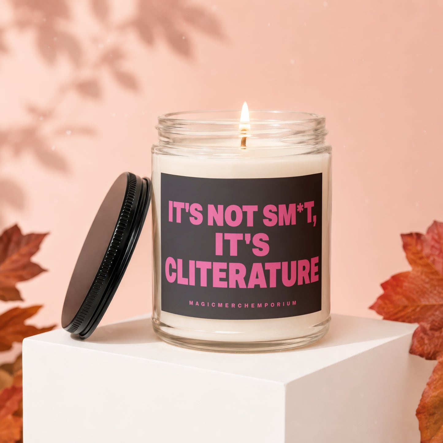 Glass candle with black lid, reading "IT'S NOT SM*T, IT'S CLITERATURE".