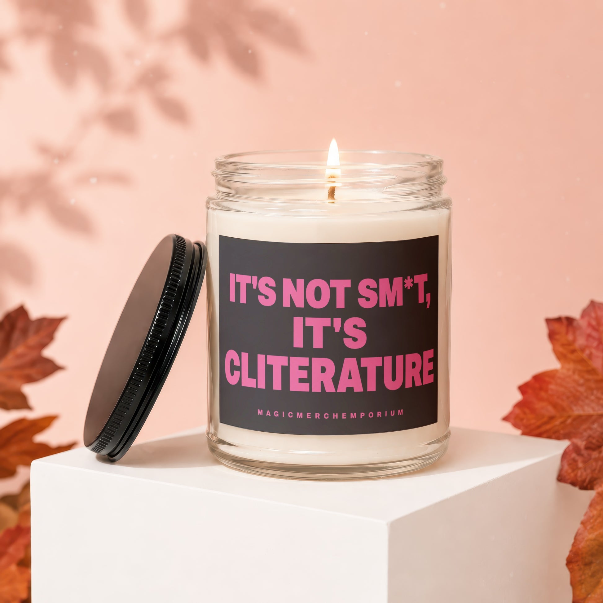 Glass candle with black lid, reading "IT'S NOT SM*T, IT'S CLITERATURE".