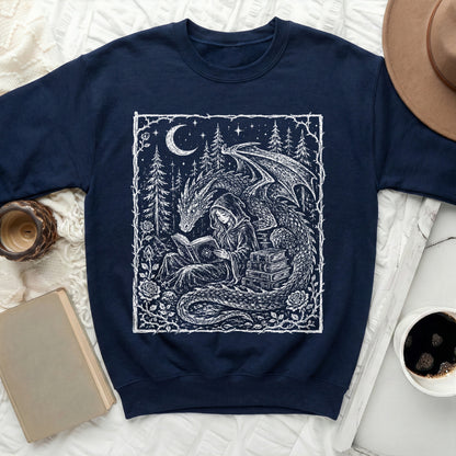 Navy sweatshirt with white print of a dragon and hooded figure reading near books.