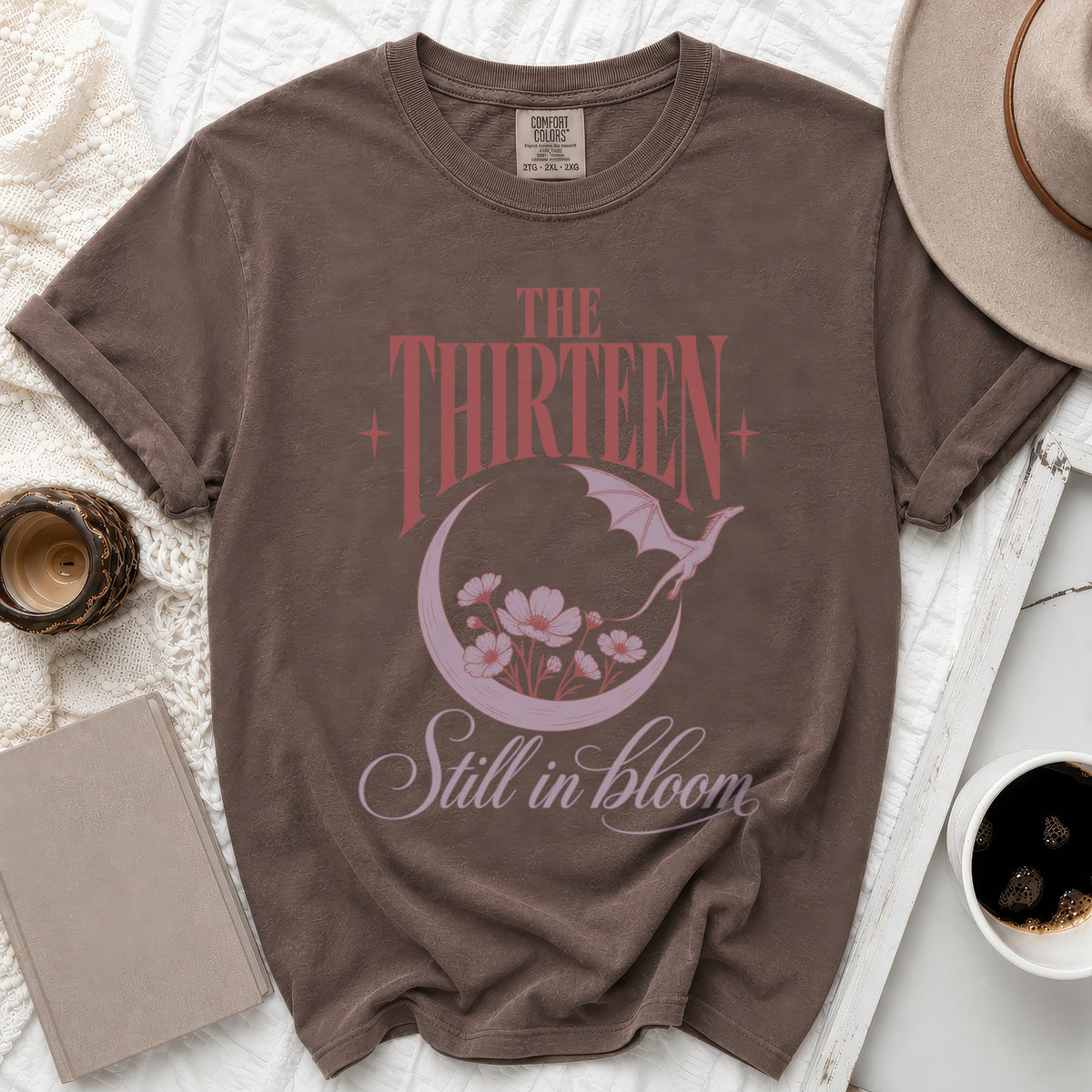 Brown t-shirt with "The Thirteen Still in bloom" text and dragon graphic.