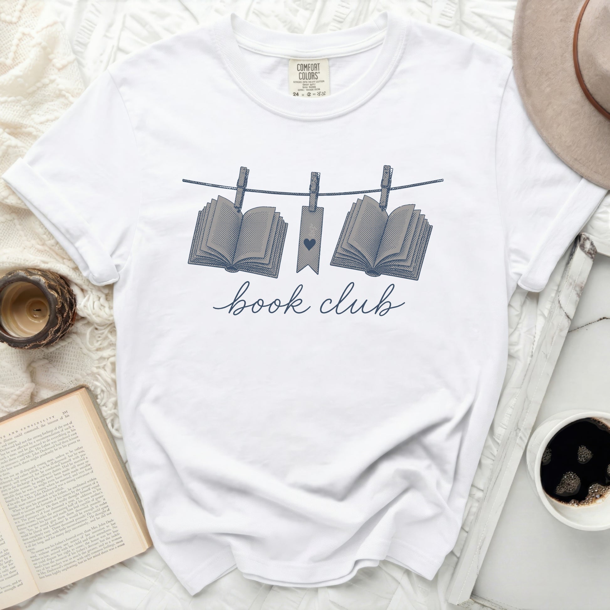 White t-shirt with "book club" and two open books on a clothesline.