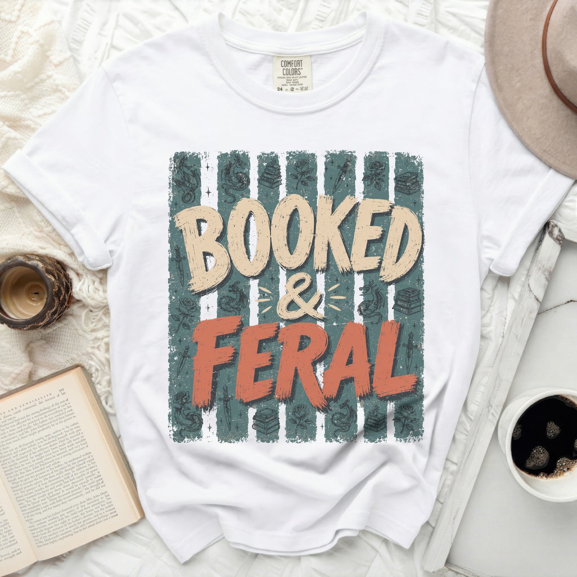 White t-shirt with "Booked & Feral" text and book-themed graphics.