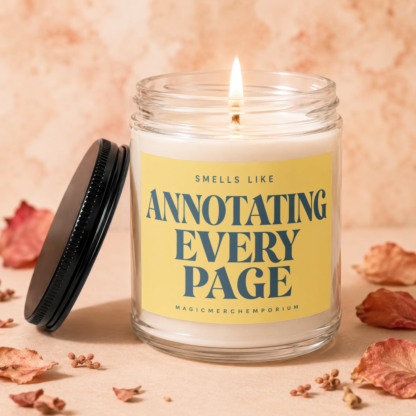 Lit candle in a glass jar with a yellow label reading "Smells Like Annotating Every Page."