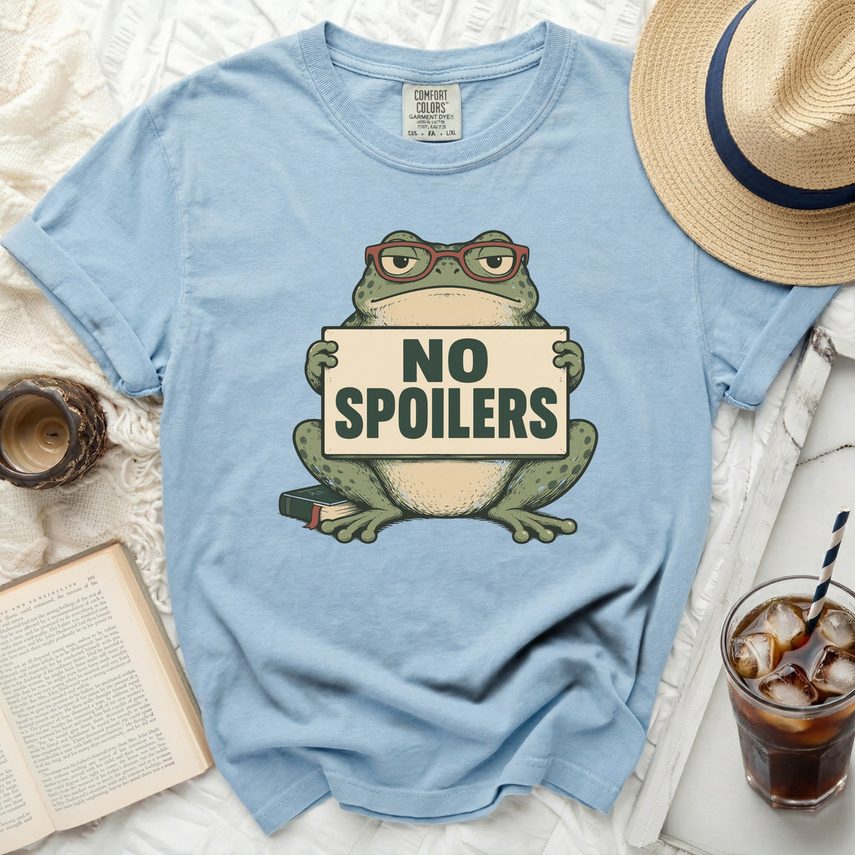 Light blue t-shirt with cartoon frog holding "NO SPOILERS" sign.
