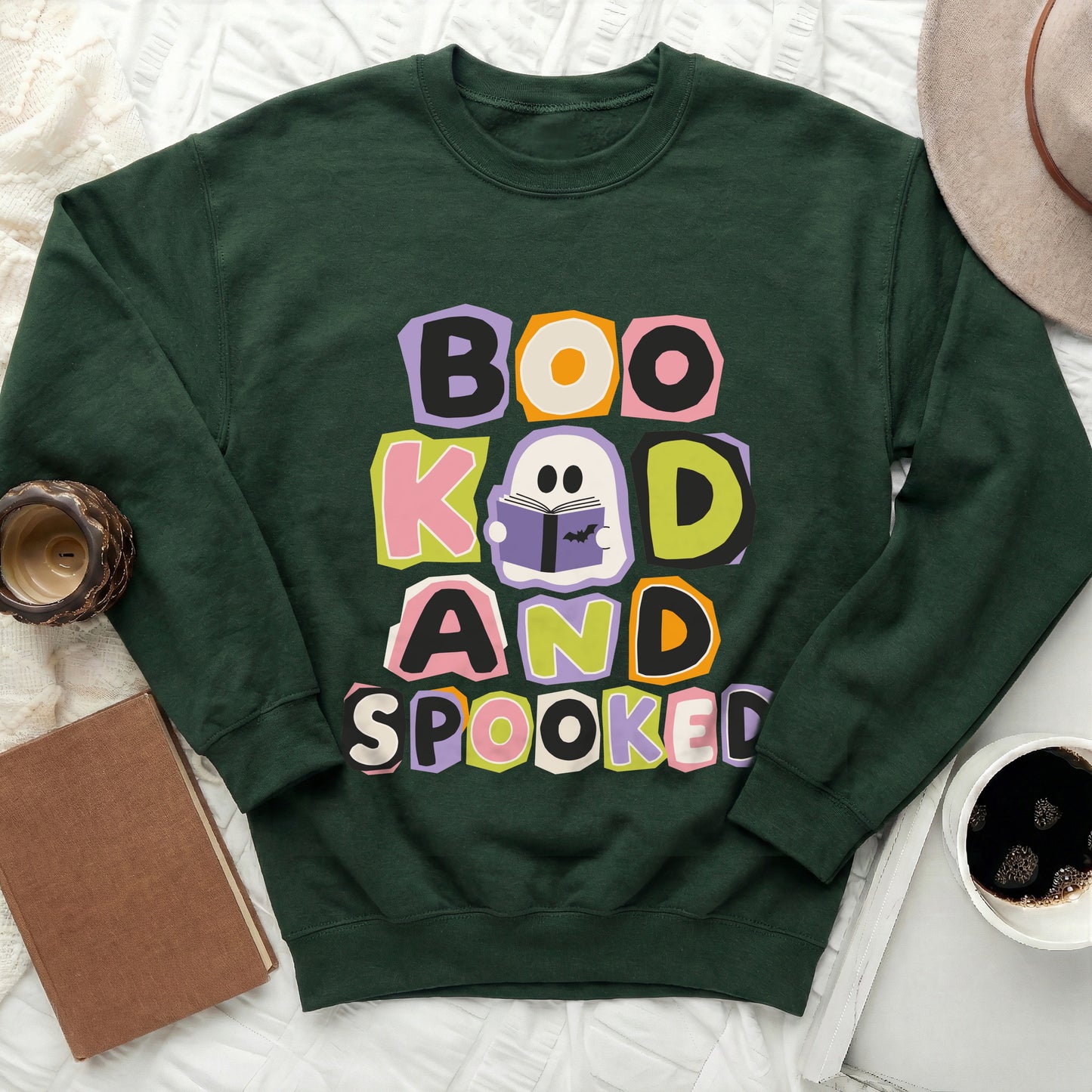 Dark green crewneck sweatshirt with "Boo Kad and Spooked" text and a ghost reading a book.