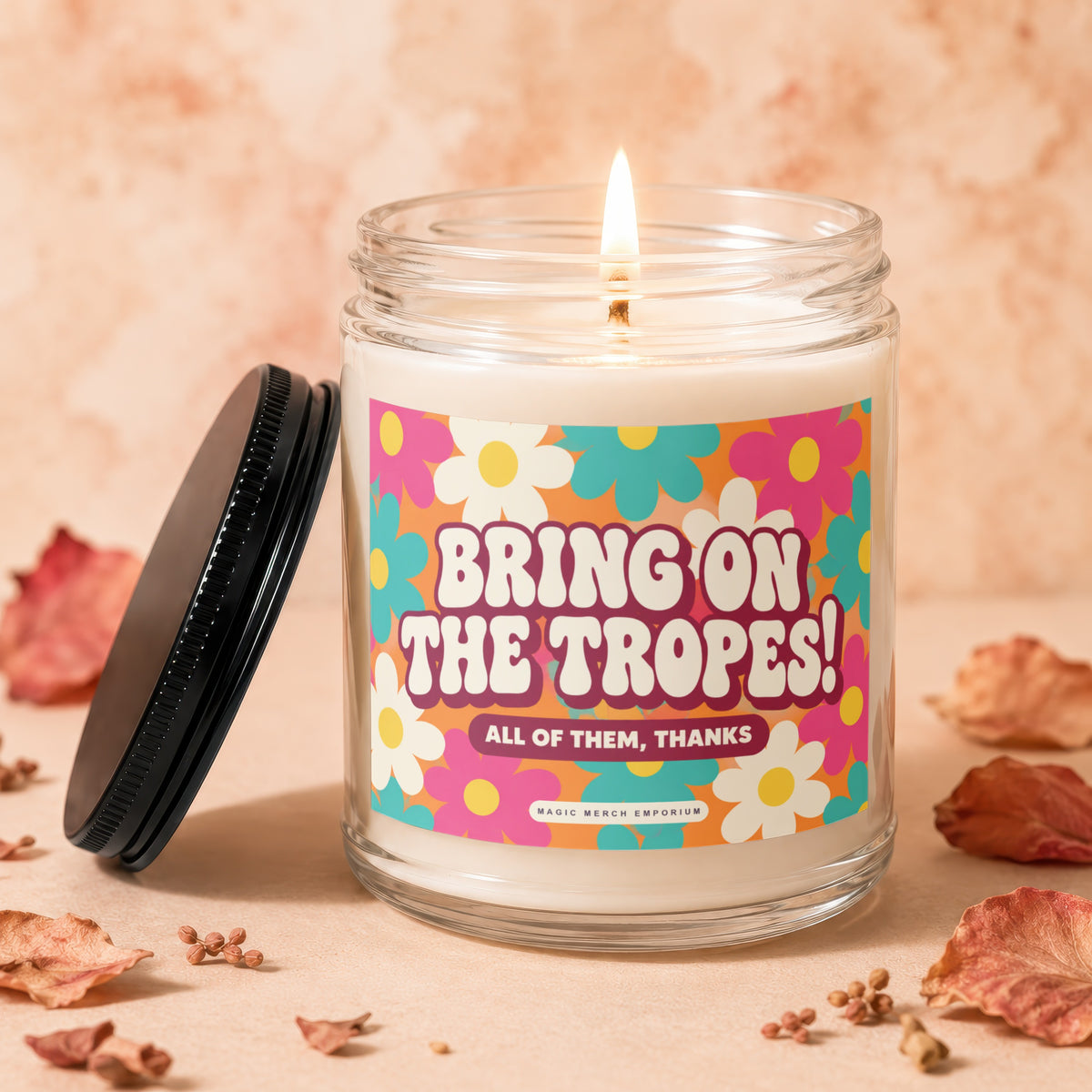 Candle with "Bring On The Tropes! All of Them, Thanks" text on a retro floral label.
