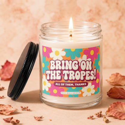 Candle with "Bring On The Tropes! All of Them, Thanks" text on a retro floral label.
