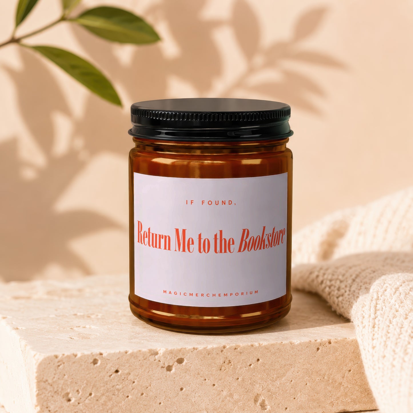 Amber candle with black lid labeled "Return Me to the Bookstore."
