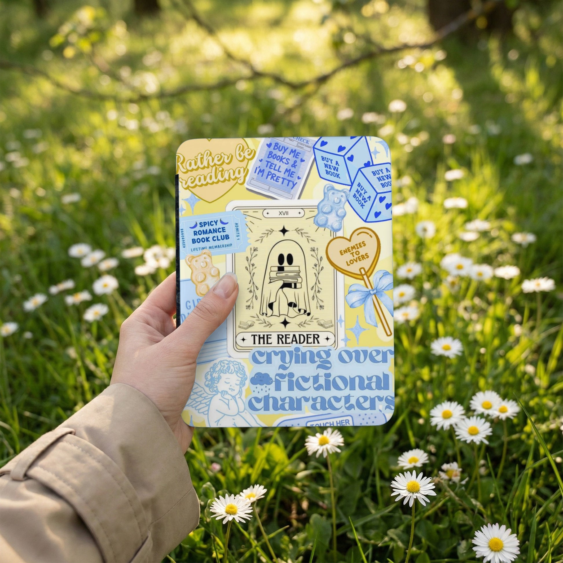 "The Reader" tarot card design with text on a square object held outdoors.