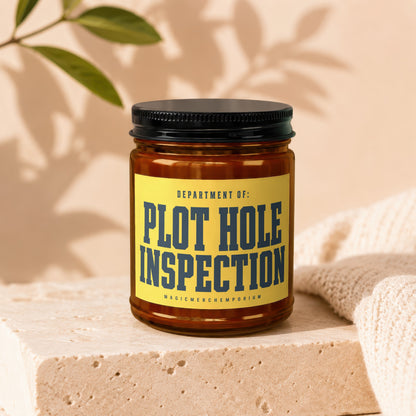 Amber jar candle with yellow label that reads "PLOT HOLE INSPECTION"