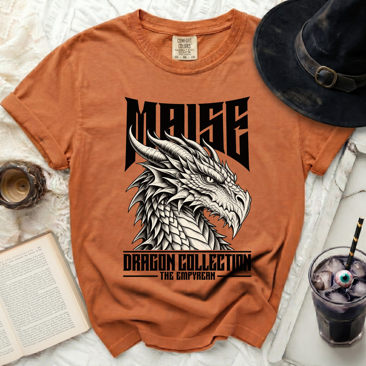 Orange t-shirt with a black dragon graphic and text "MAISE DRAGON COLLECTION THE EMPYREAN".