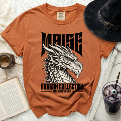 Orange t-shirt with a black dragon graphic and text "MAISE DRAGON COLLECTION THE EMPYREAN".