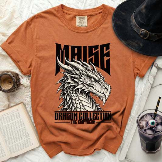 Orange t-shirt with a black dragon graphic and text "MAISE DRAGON COLLECTION THE EMPYREAN".