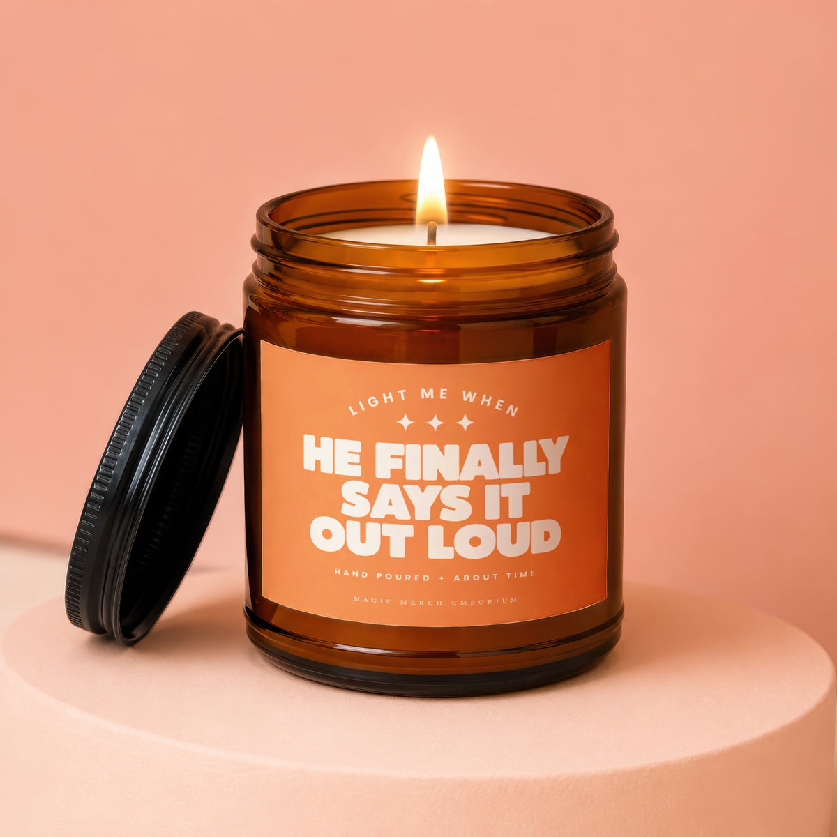 Amber jar candle with lit flame and text "He finally says it out loud."