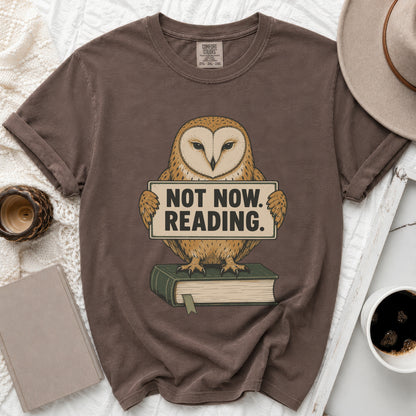 Brown t-shirt with a barn owl holding a sign that says "NOT NOW. READING."