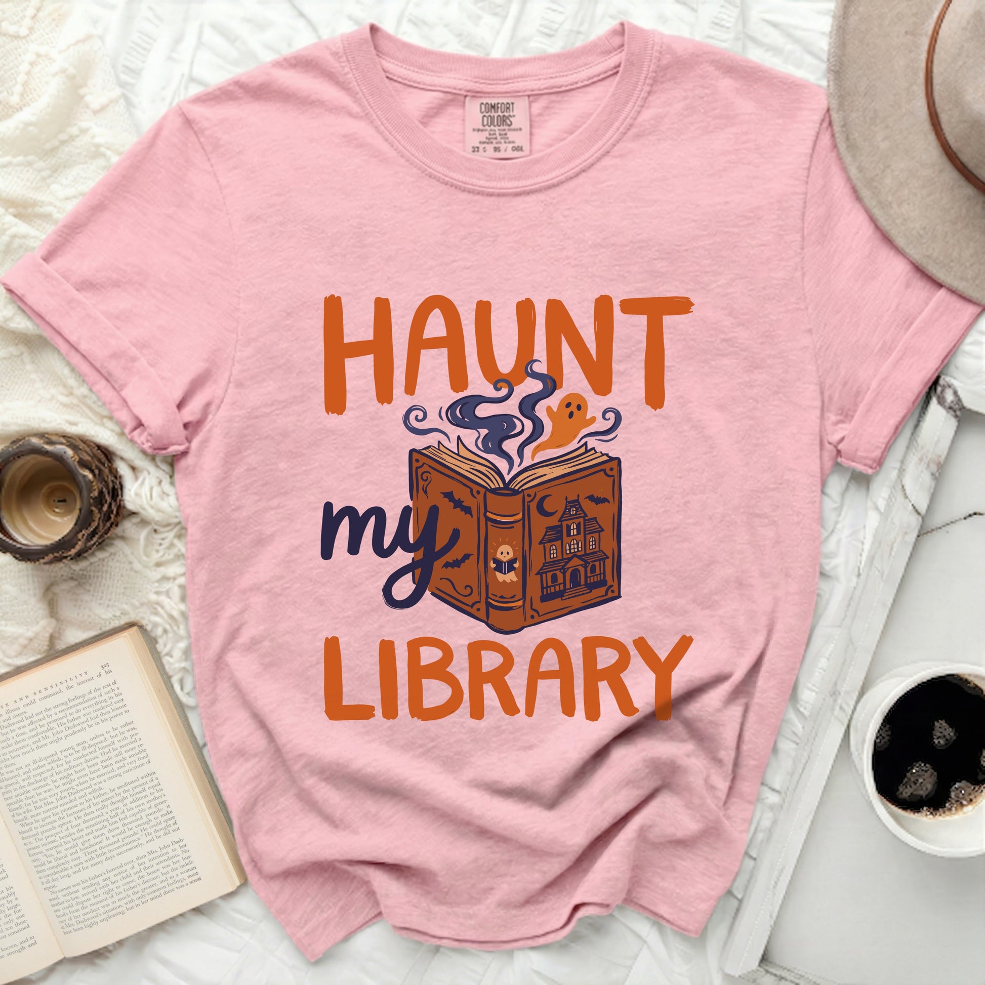 Pink comfort colors t-shirt with "Haunt my Library" Halloween graphic.