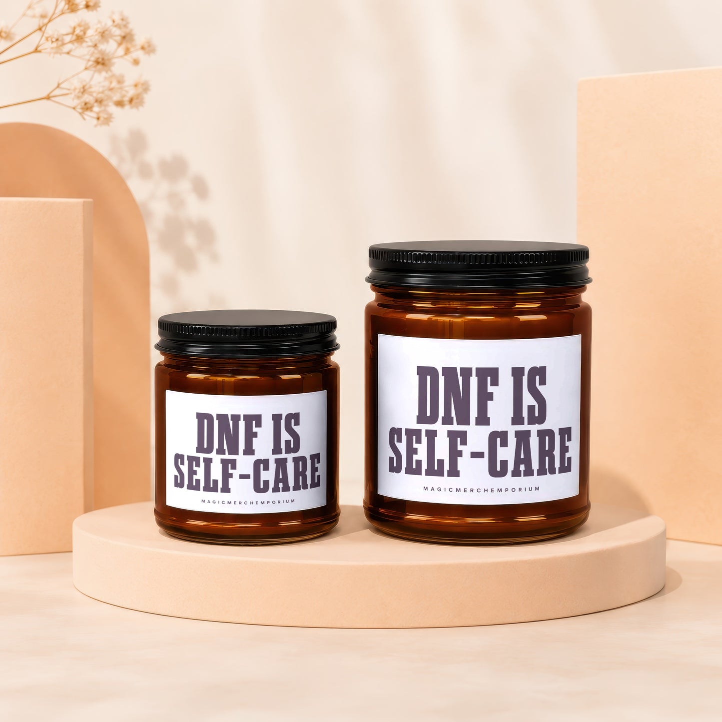 Two amber glass candles with black lids, labels read "DNF IS SELF-CARE".