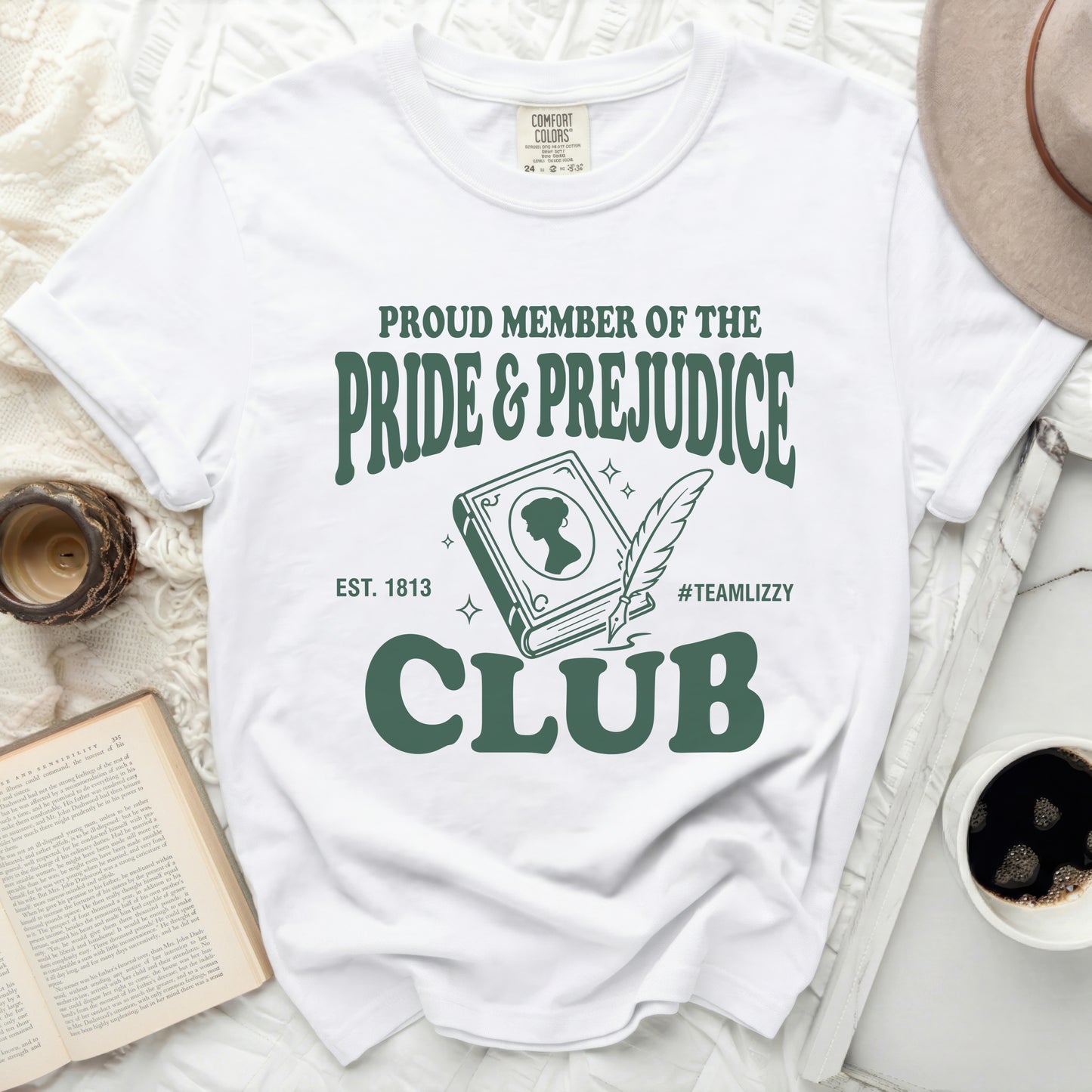 White t-shirt with "Pride & Prejudice Club" graphic in green.