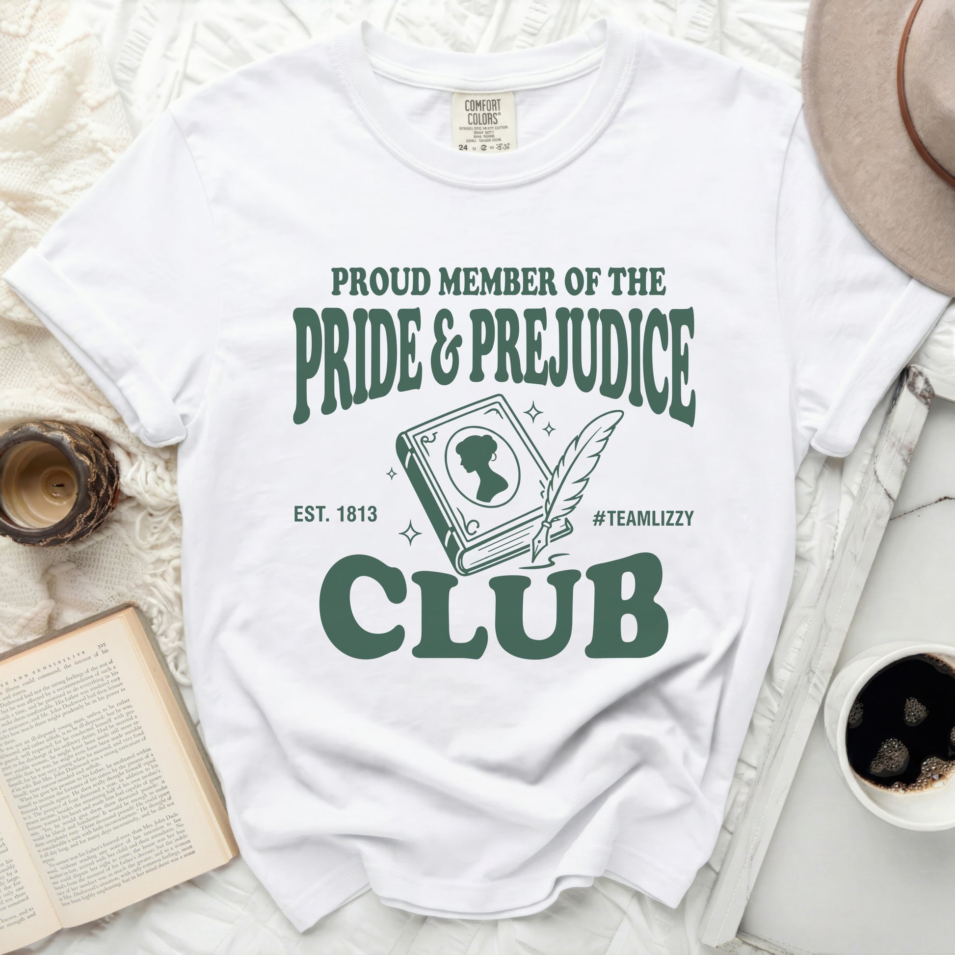 White t-shirt with "Pride & Prejudice Club" graphic in green.