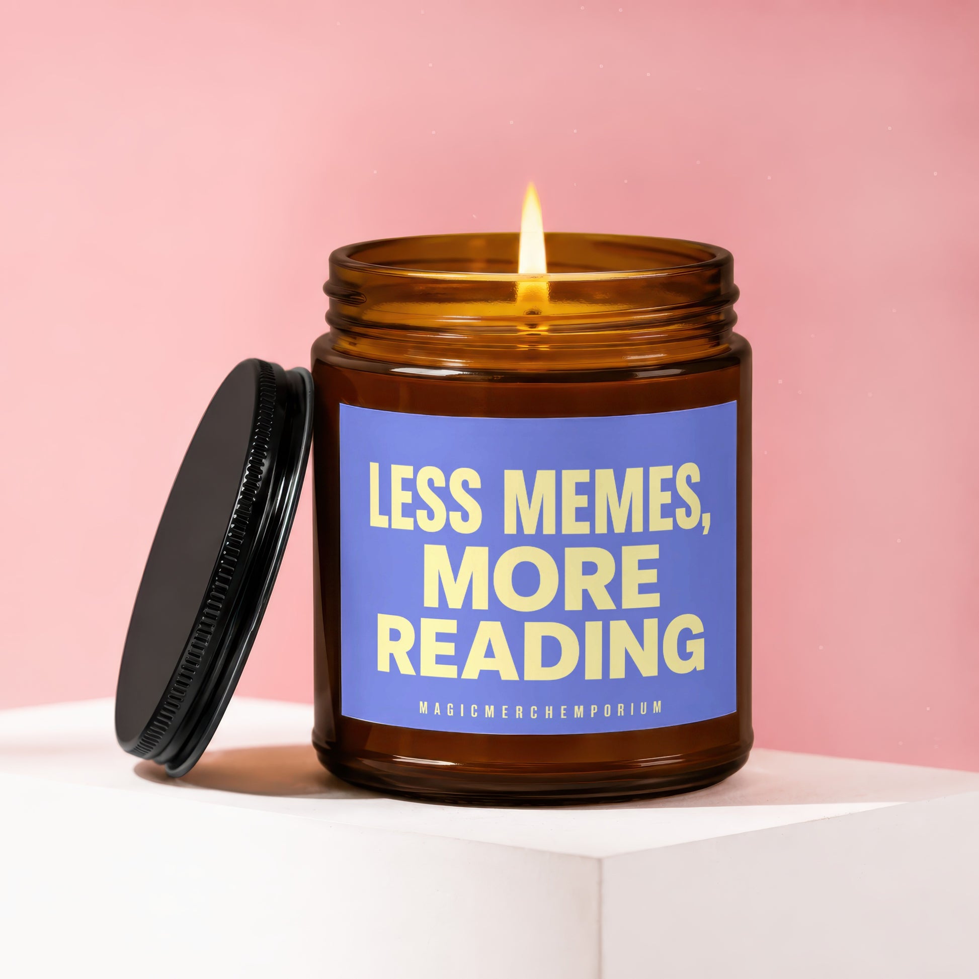 Candle with "LESS MEMES, MORE READING" text and lit flame on a pink background.