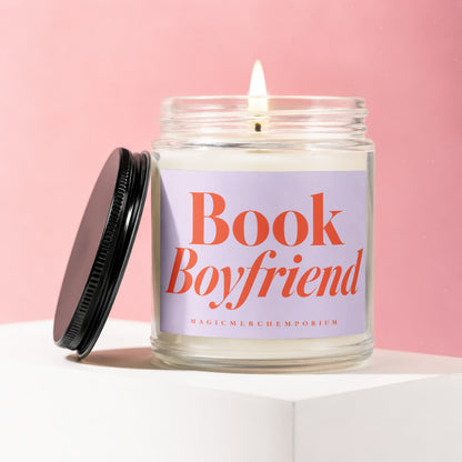 Jar candle with "Book Boyfriend" text and lit wick on a pink background.