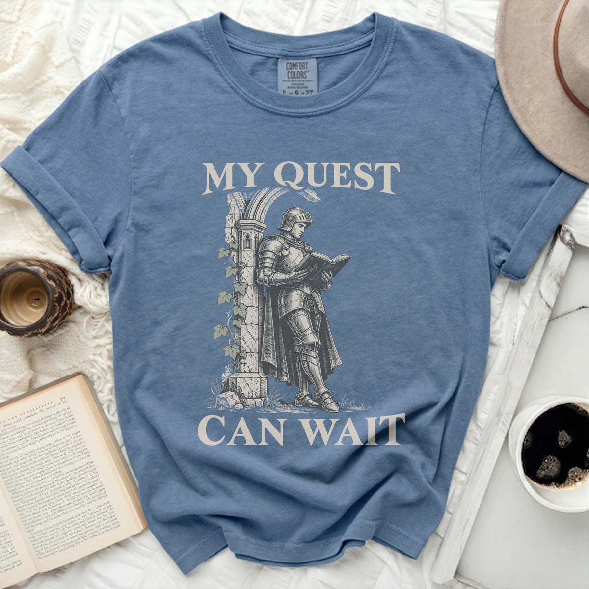 Knight in armor reads a book under text "MY QUEST CAN WAIT".