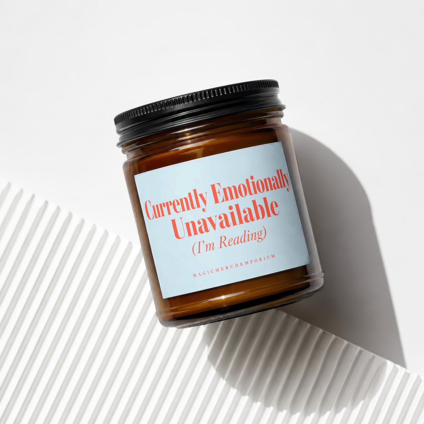 Brown glass candle with a light blue label reading "Currently Emotionally Unavailable (I'm Reading)".